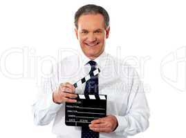 Aged corporate male holding clapperboard
