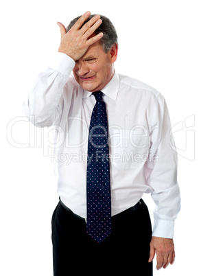 Sad old corporate man with hand on head