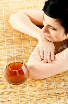 Spa woman relaxing with a wine glass beside her