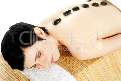 Woman getting spa treatment with hot stone