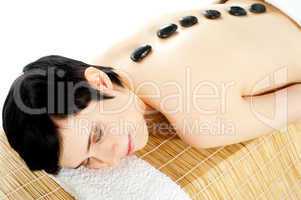 Woman getting spa treatment with hot stone