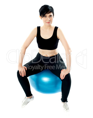 Young athlete sitting on a swiss ball