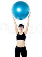 Beautiful woman holding pilates ball