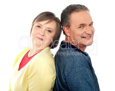 Portrait of senior couple back to back in studio