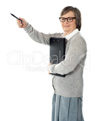 Female executive pointing away with pen in hand