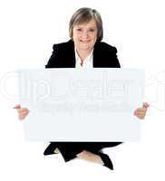 Corporate lady sitting on floor with a blank billboard
