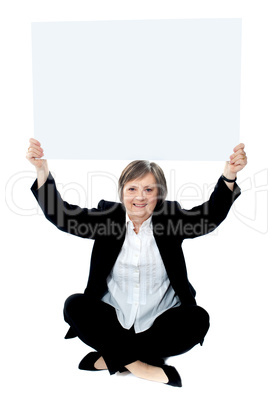 Seated businesswoman holding blank whiteboard
