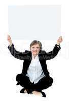 Seated businesswoman holding blank whiteboard