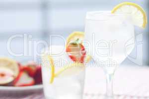 cocktail with ice,lemon, fig and strawberries on a plate