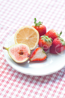 lemon, fig and strawberries on a plate