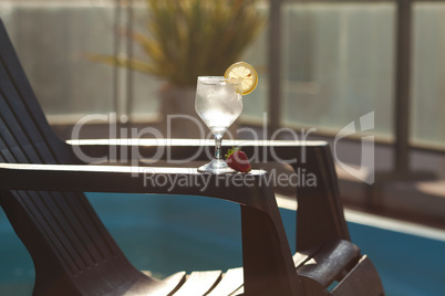 Swimming pool, lounge, a wine glass with ice, lemon and strawber