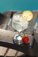 Swimming pool, lounge, a wine glass with ice, lemon and strawber