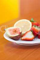 lemon, fig and strawberries on a plate