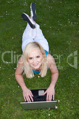 Woman using her laptop on the grass