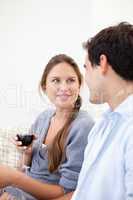 Young Couple watching each other while holding a glass