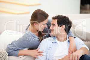 Couple embracing eachother while sitting a sofa