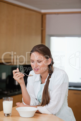 Woman looking at her spoon while eating cereals