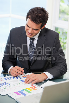 Man sitting on a chair while looking at graph