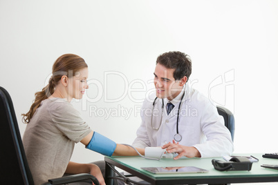 Doctor taking blood pressure of a patient