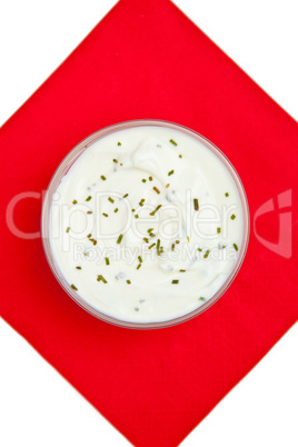 Close up of a bowl of dip with herbs on a red napkin against a w Close up of a bowl of dip with herbs on a red napkin against a w