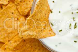 Close up of a nacho dipped into a bowl of dip