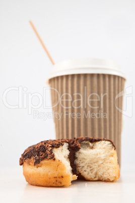 An half eaten doughnut and a cup of coffee placed together