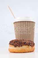 A doughnut and a cup of coffee placed together