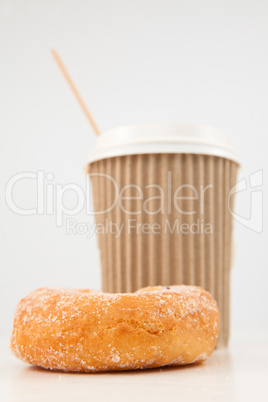 A doughnut and a cup of coffee placed side by side