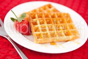 Waffles and strawberry together in a white plate