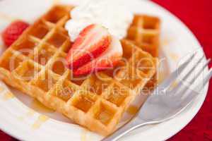 Waffles with whipped cream and strawberry on it
