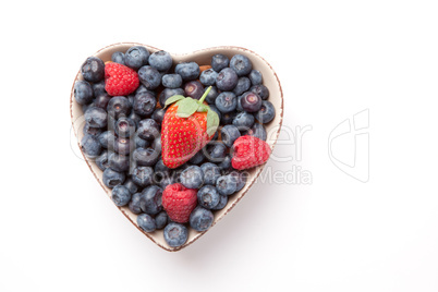 Different berries in  a heart shaped bowl