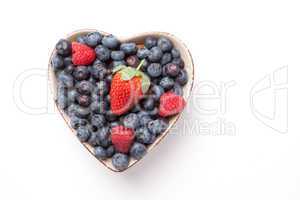 Different berries in  a heart shaped bowl