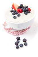 Berries cream in a bowl with a tape measure