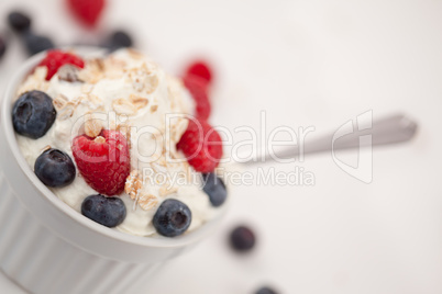 Jar of fruits and whipped cream with spoon