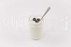 Pot of yoghurt with three blueberries