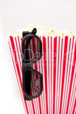 Glasses hanging on a box full of popcorn