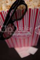Glasses hanging on the edge of a box of pop corn