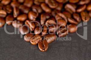 Blurred coffee seeds laid out together on a black table