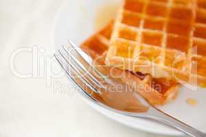 Two waffles and a fork on a saucer