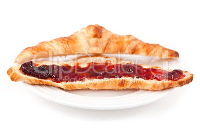 Croissant spread with jam in a plateful