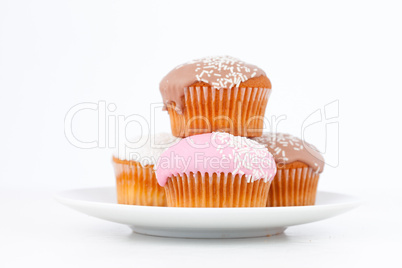 Muffins with icing sugar piles up on a white plate