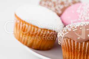Close up of muffins with icing sugar on a white plate