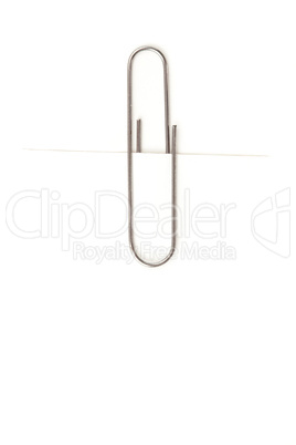 Close up of a grey paperclip attaching on a white paper