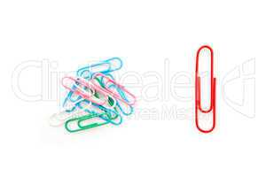Big red paper clip and many paper clips side by side