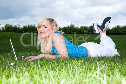 Girl lying on the grass working on a laptop