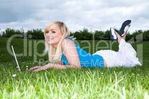 Girl lying on the grass working on a laptop