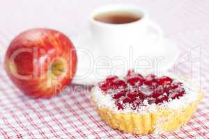 beautiful cake with berries,apple and tea on plaid fabric