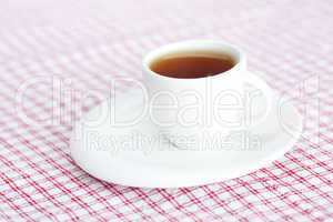 cup of tea on plaid fabric