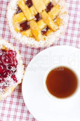 beautiful cake with berries and tea on plaid fabric