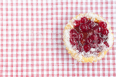 beautiful cake with berries on plaid fabric